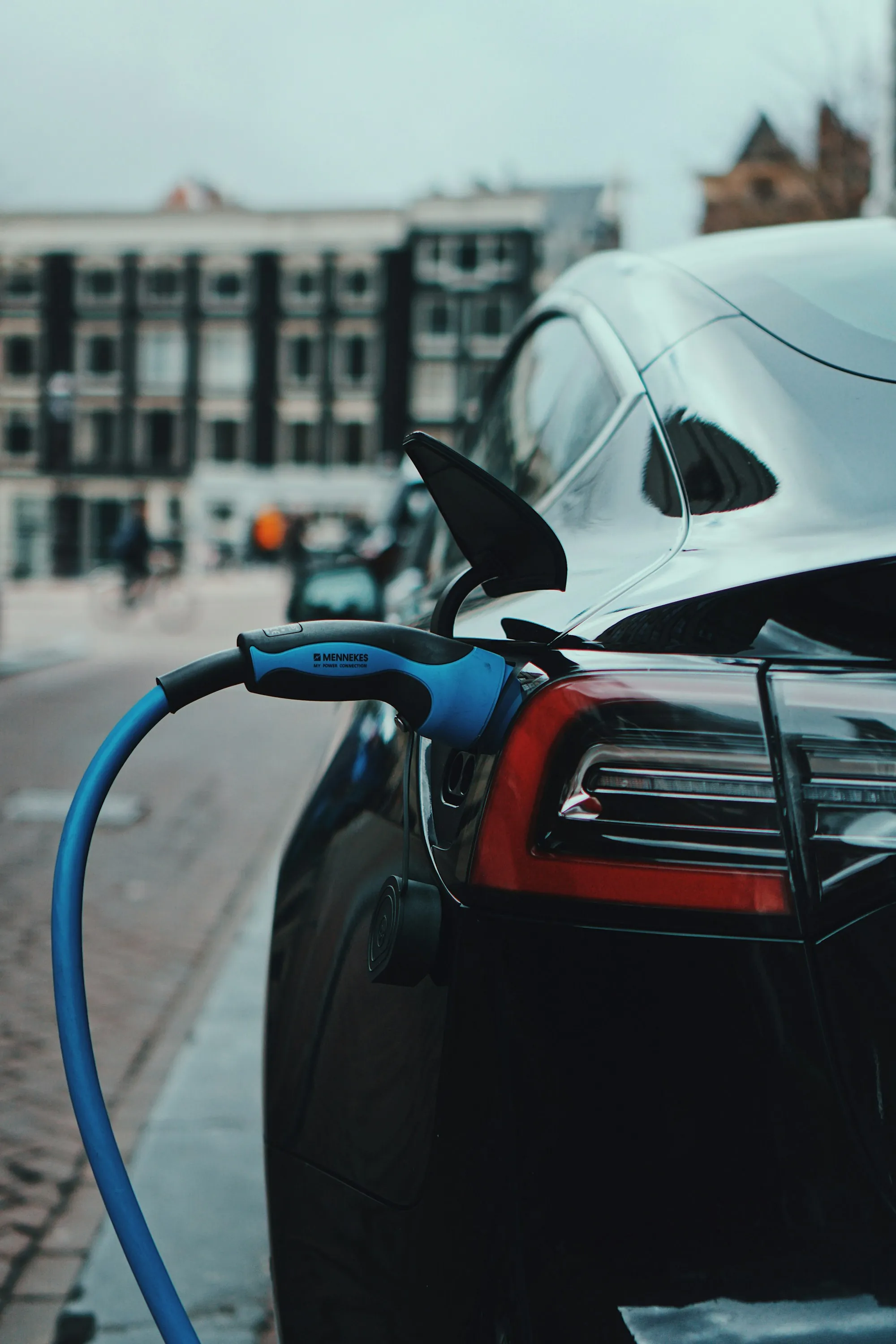 Electric car on a lift with its front bumper removed in a clean repair bay