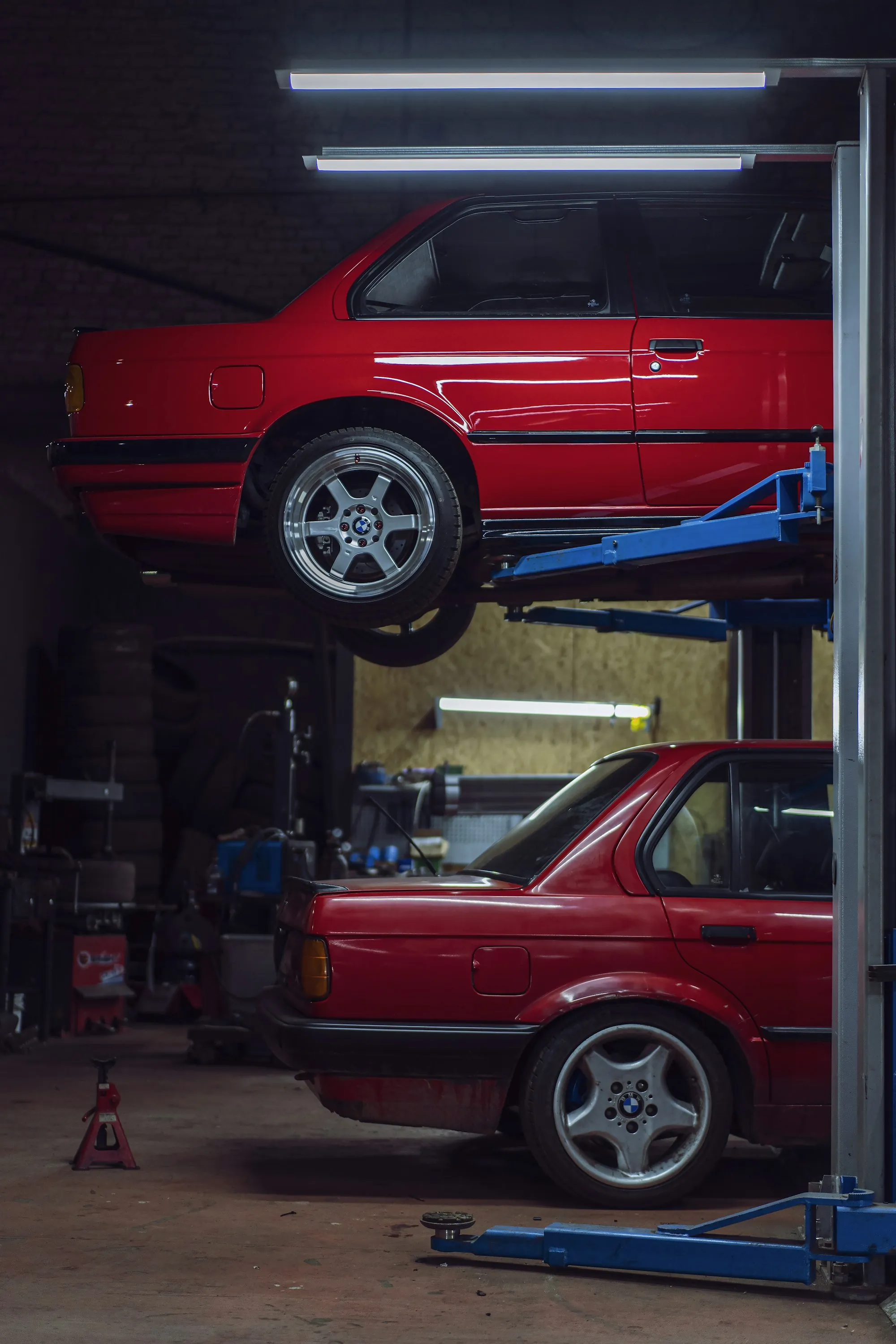 Compact car clamped to a frame straightening bench with chains and towers attached