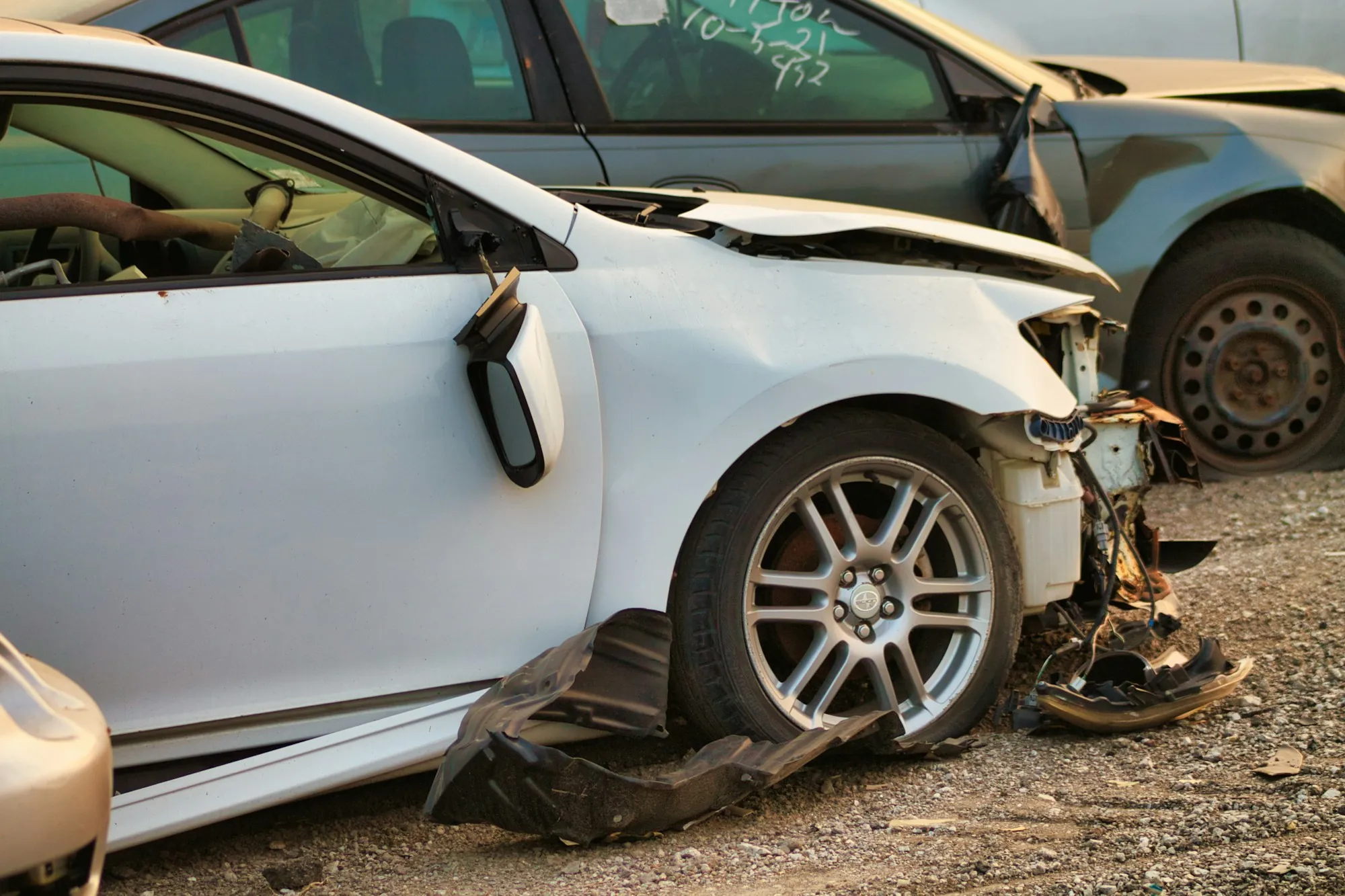 Shop estimator photographing a dented car door for an insurance estimate
